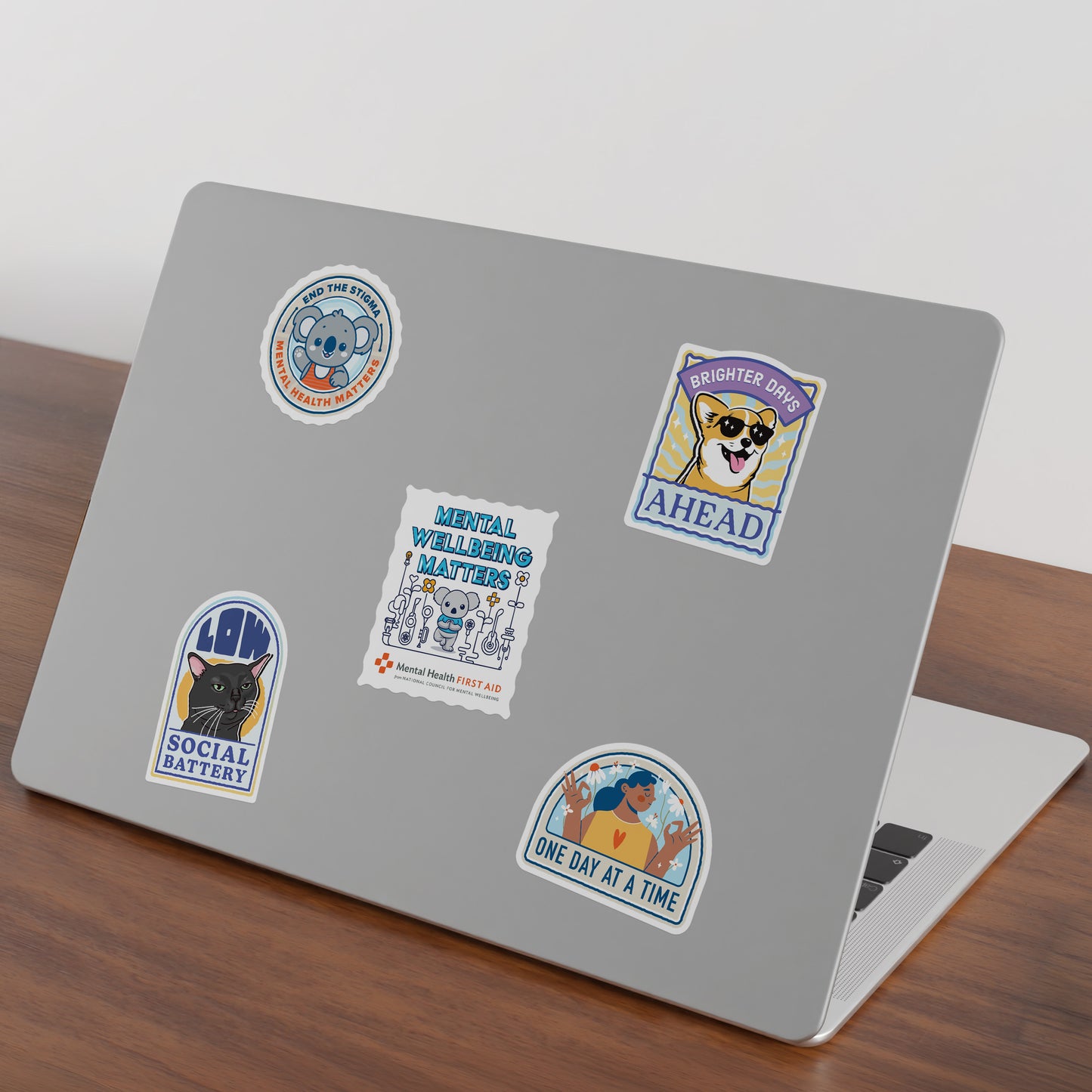 Laptop with various stickers on a wooden surface