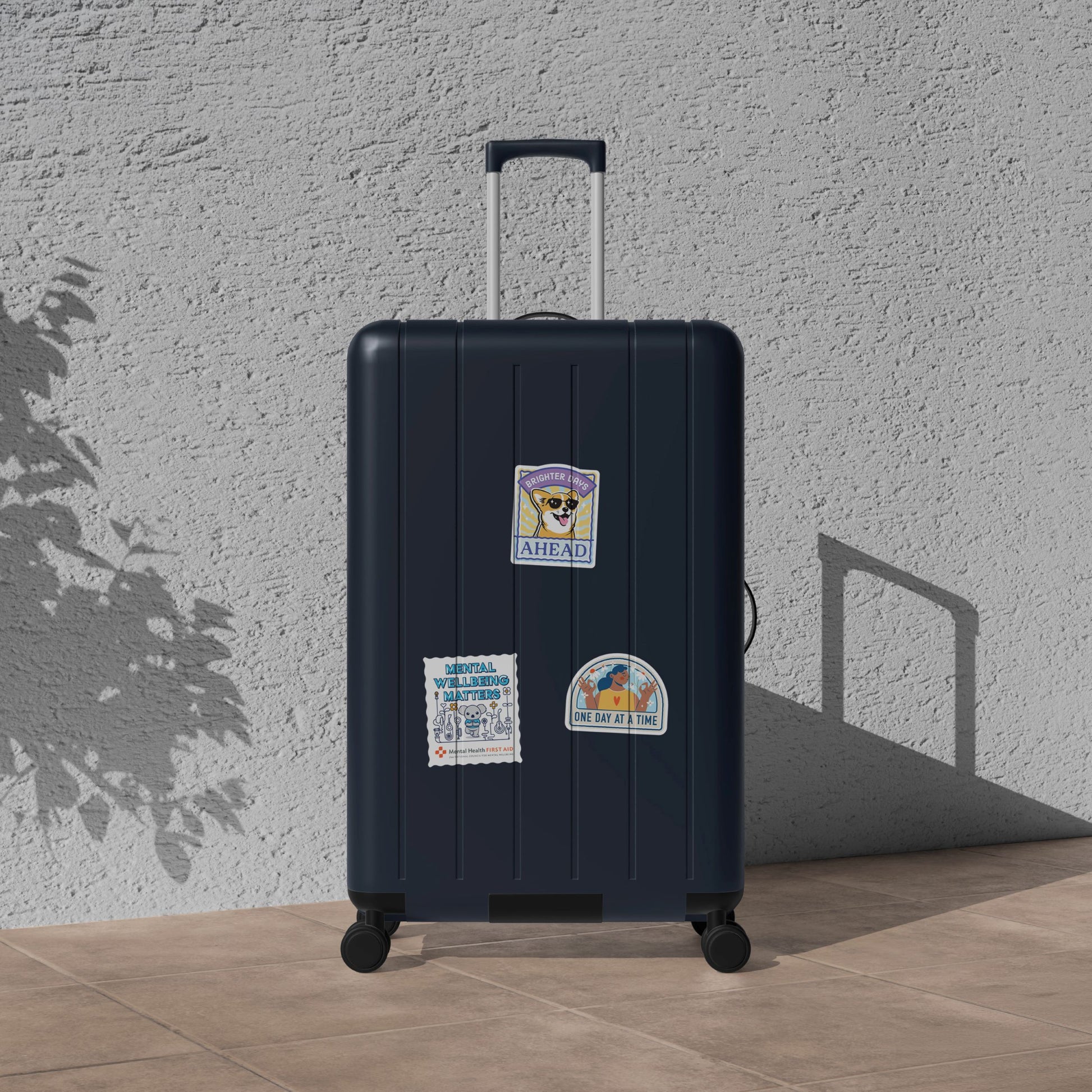 Black suitcase with stickers against a light gray wall